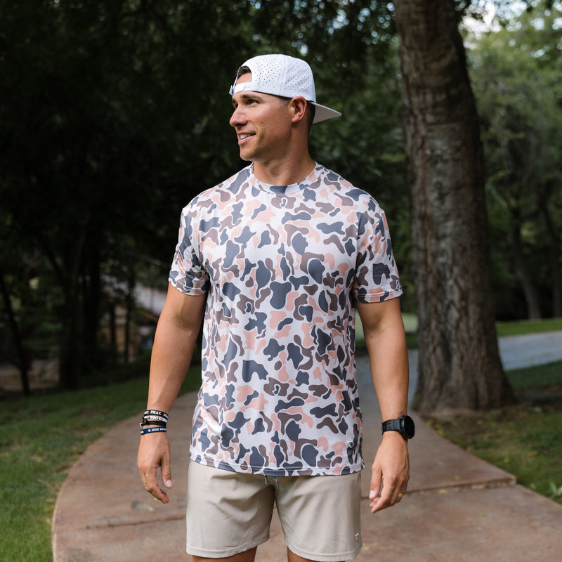Man wearing a patterned shirt and cap outdoors
