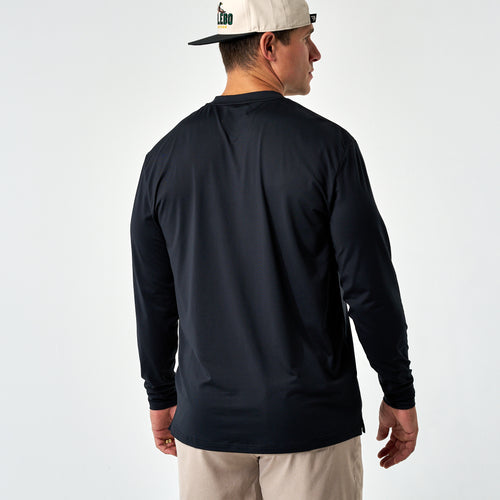 Back view of a man wearing the Black Long Sleeve Go To Tee and a cream cap