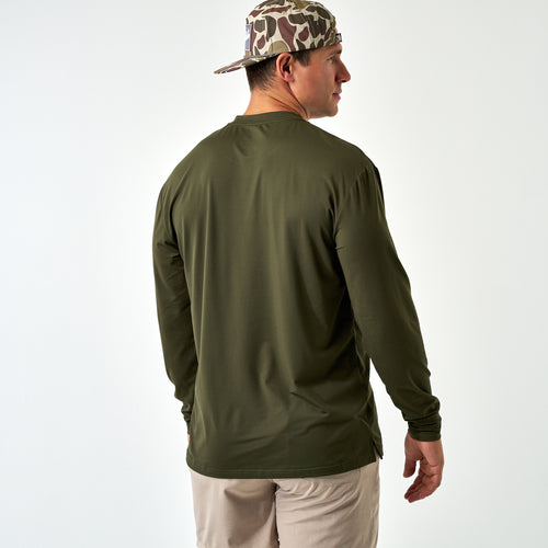 Back view of a man wearing the Mallard Green Long Sleeve Go To Tee and a camo cap