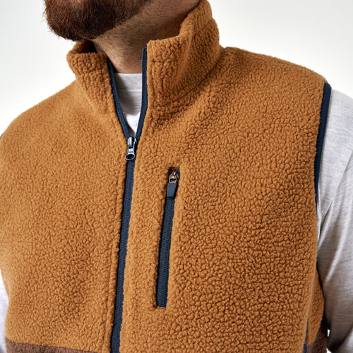 Close-up of the Multi Brown Montana Vest tan sherpa collar, navy center zip, and chest zip pocket