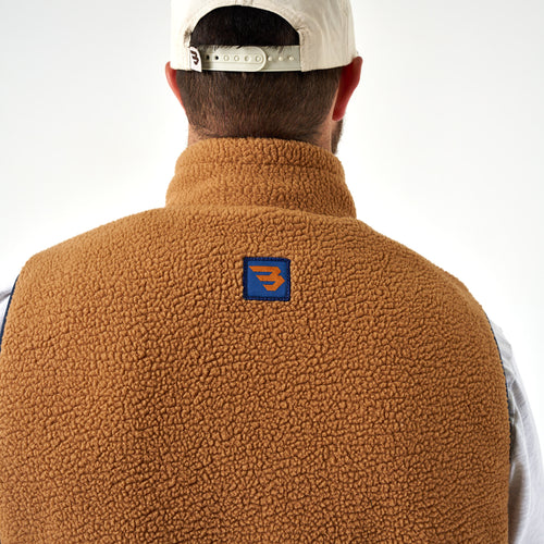 Back collar of the Multi Brown Montana Vest in tan sherpa with a navy patch and orange B logo