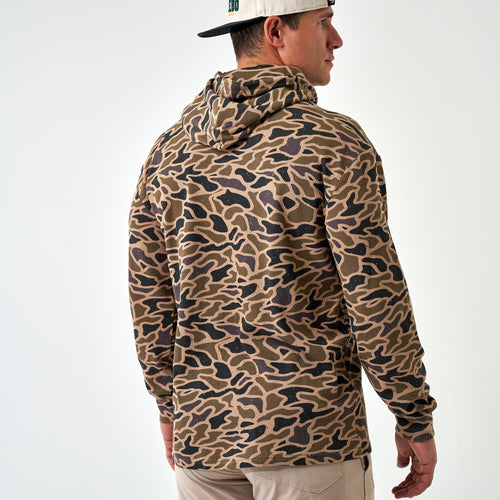 Back of the Gauge Camo Thermal Hoodie worn by a man in a white cap