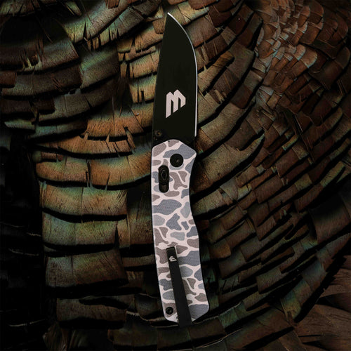 Open Classic Deer Camo Everyday Carry Knife from Williams Knife Co laid on turkey feathers