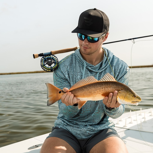 Person holding a fish on a boat with water in the background